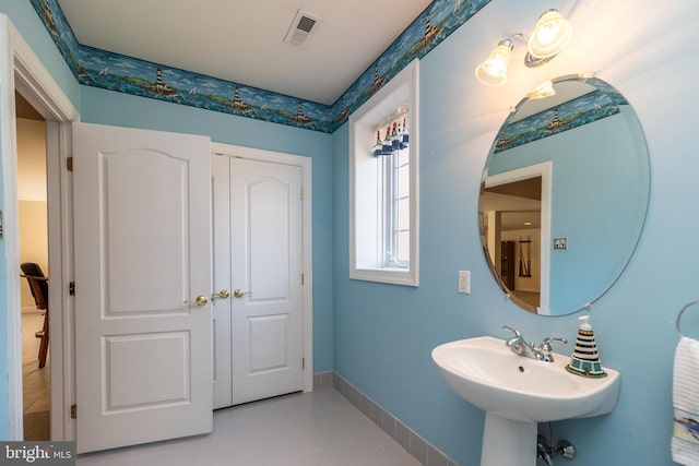 bathroom with tile patterned flooring, baseboards, visible vents, and a sink