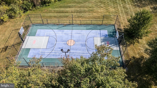 view of basketball court featuring a yard, community basketball court, and fence