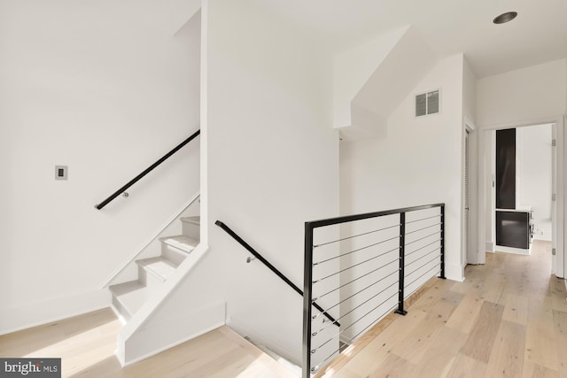 stairway featuring baseboards, visible vents, and wood finished floors