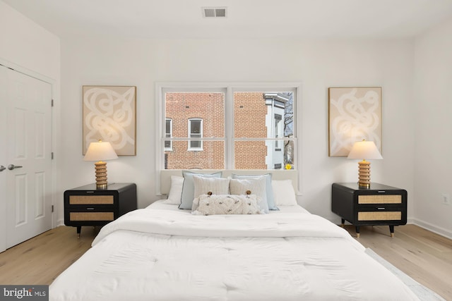 bedroom with light wood-style flooring and visible vents