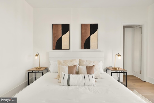 bedroom featuring baseboards and wood finished floors