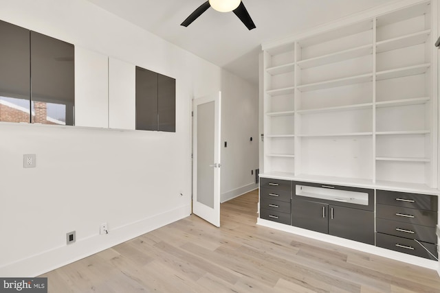 interior space featuring a ceiling fan, light wood-style flooring, and baseboards