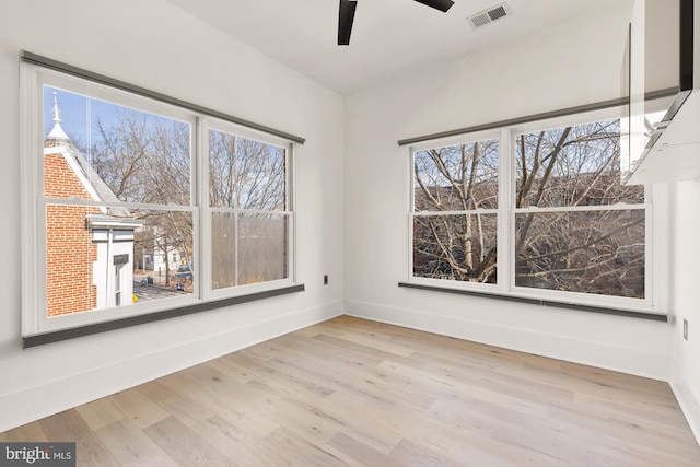 unfurnished room with visible vents, ceiling fan, baseboards, and wood finished floors