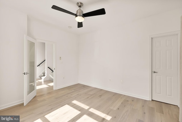 unfurnished bedroom featuring ceiling fan, light wood-style flooring, and baseboards