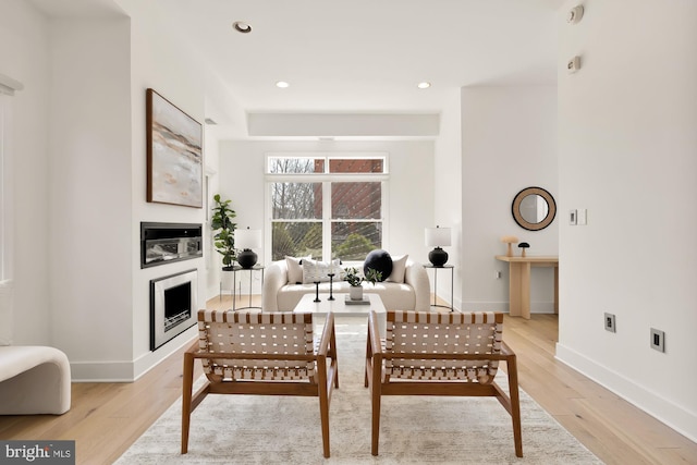 interior space with baseboards, a fireplace, and light wood finished floors