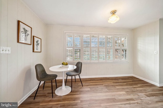 dining space with baseboards and wood finished floors