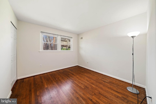 unfurnished bedroom with visible vents, a closet, baseboards, and hardwood / wood-style floors