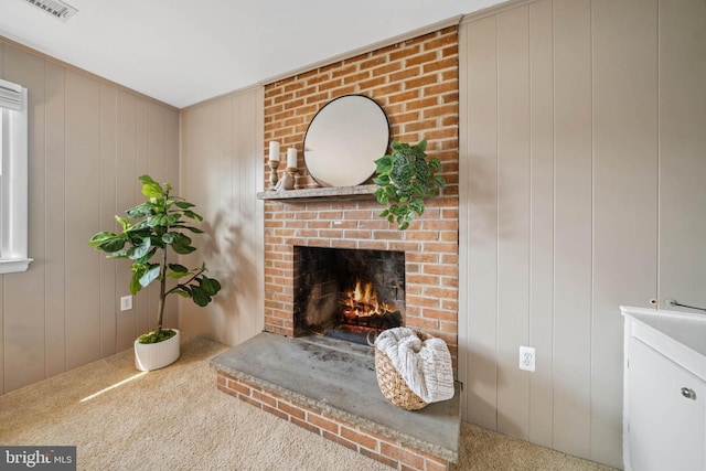 carpeted living area with visible vents and a fireplace