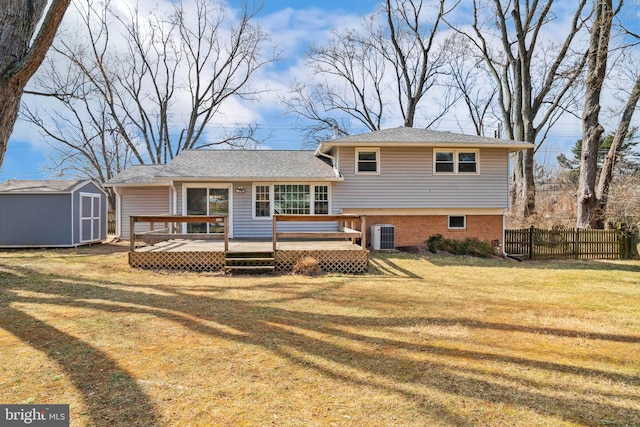 back of property featuring a storage shed, an outbuilding, a yard, fence, and a wooden deck