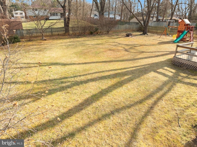 view of yard featuring a fenced backyard and a playground