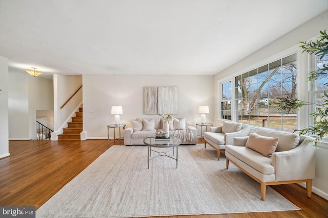 living room with stairway, baseboards, and wood finished floors