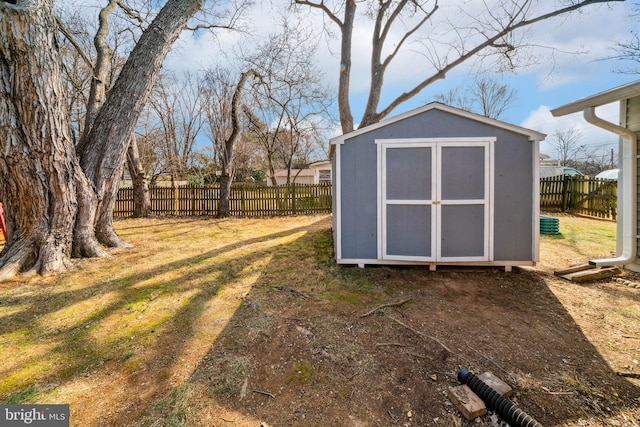 view of yard featuring a fenced backyard, an outdoor structure, and a shed