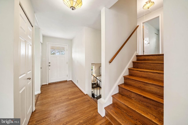 entryway featuring stairway, baseboards, and wood finished floors