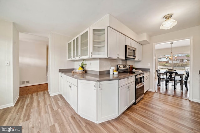 kitchen featuring light wood finished floors, white cabinetry, visible vents, and stainless steel appliances