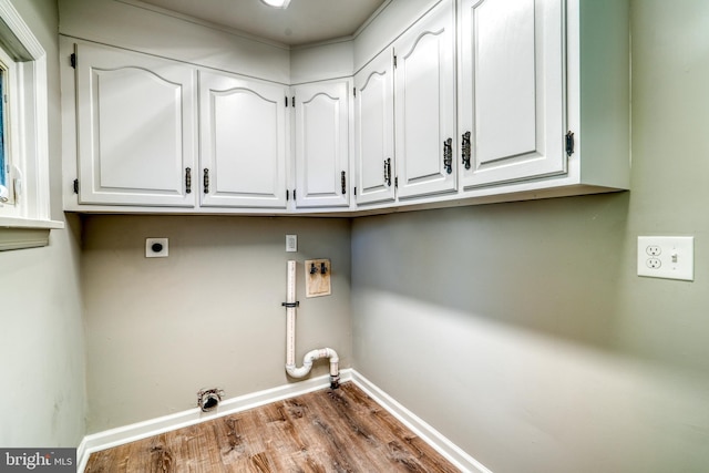 washroom with gas dryer hookup, wood finished floors, baseboards, cabinet space, and electric dryer hookup