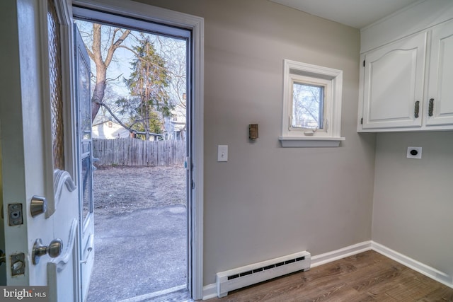 doorway with dark wood-style floors, baseboards, and baseboard heating