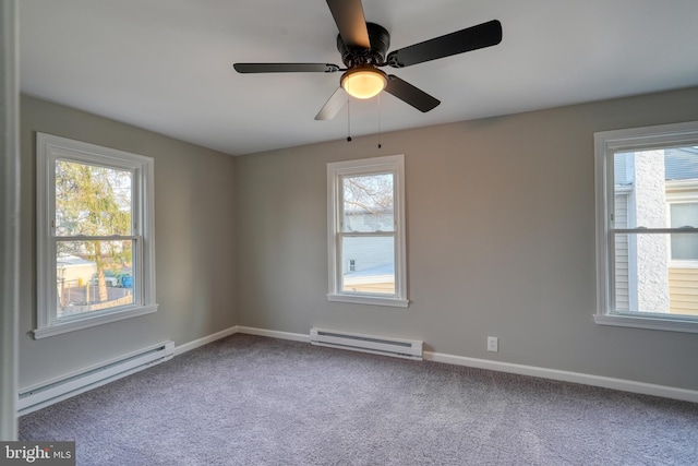 carpeted empty room with a baseboard heating unit, plenty of natural light, and baseboards