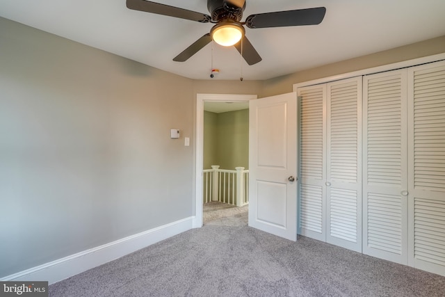 unfurnished bedroom featuring carpet floors, a ceiling fan, baseboards, and a closet