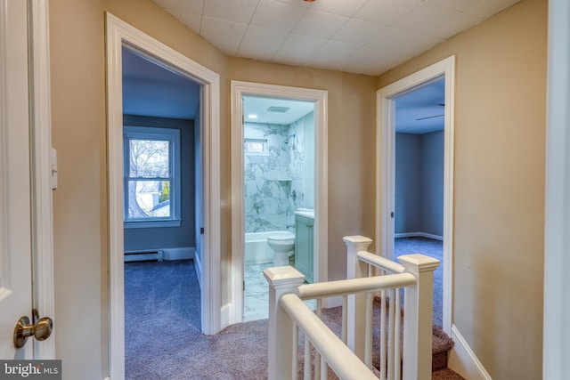 hall with carpet floors, a baseboard radiator, baseboards, and an upstairs landing