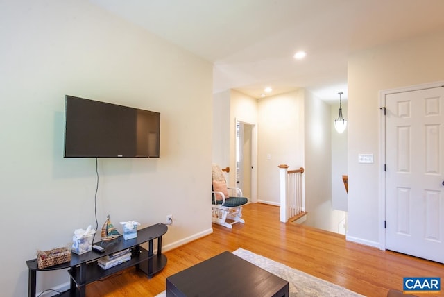 living room with baseboards, wood finished floors, and recessed lighting