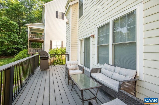 wooden deck featuring area for grilling and an outdoor living space