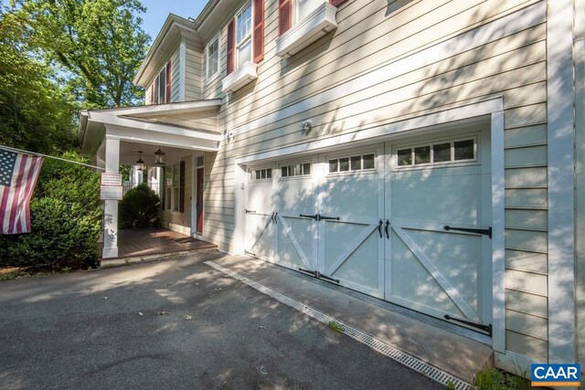 view of side of home featuring a garage and aphalt driveway