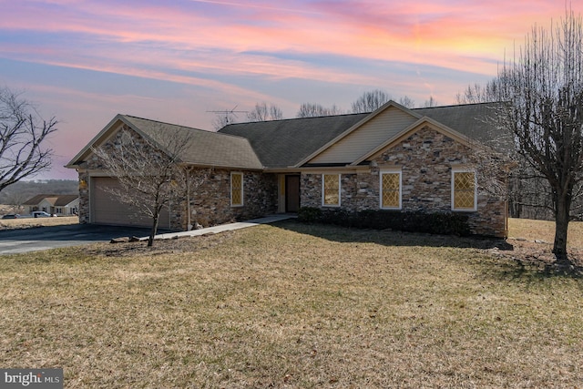 view of front facade with a garage, a yard, and driveway