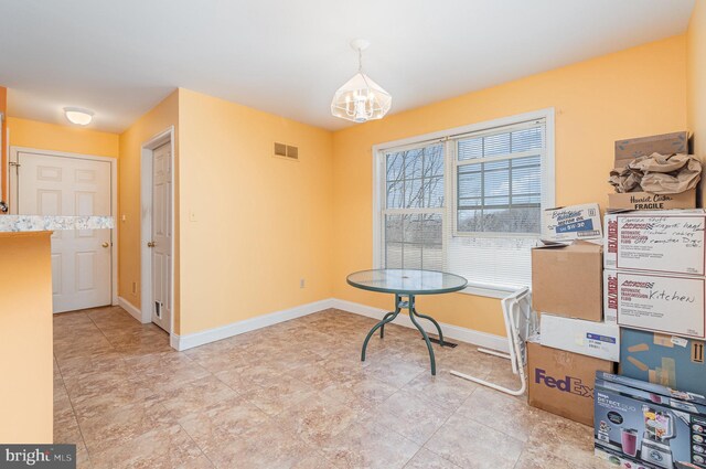 dining space featuring visible vents, an inviting chandelier, and baseboards