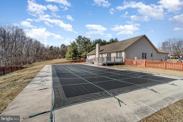 view of pool featuring a wooden deck and fence