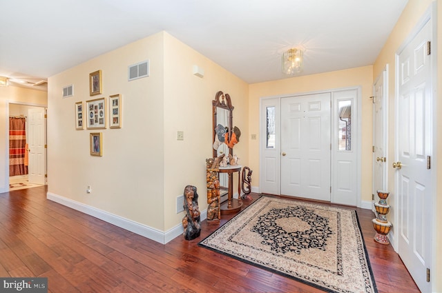 entrance foyer with visible vents, baseboards, and dark wood-style flooring