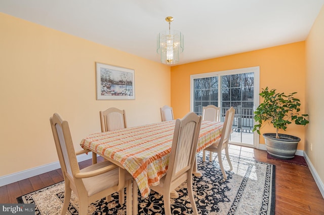 dining room featuring a chandelier, baseboards, and hardwood / wood-style floors