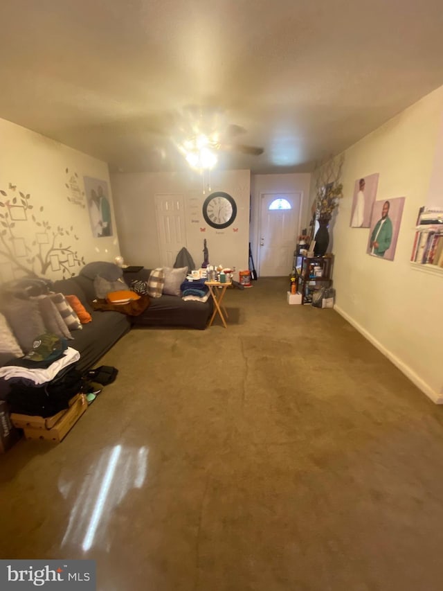 unfurnished living room featuring a ceiling fan and baseboards