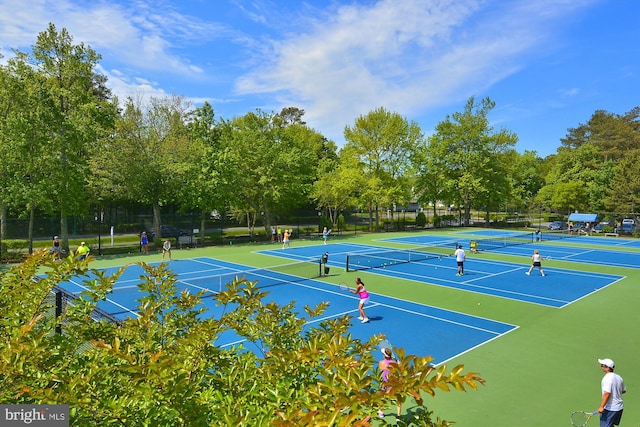 view of tennis court featuring community basketball court and fence
