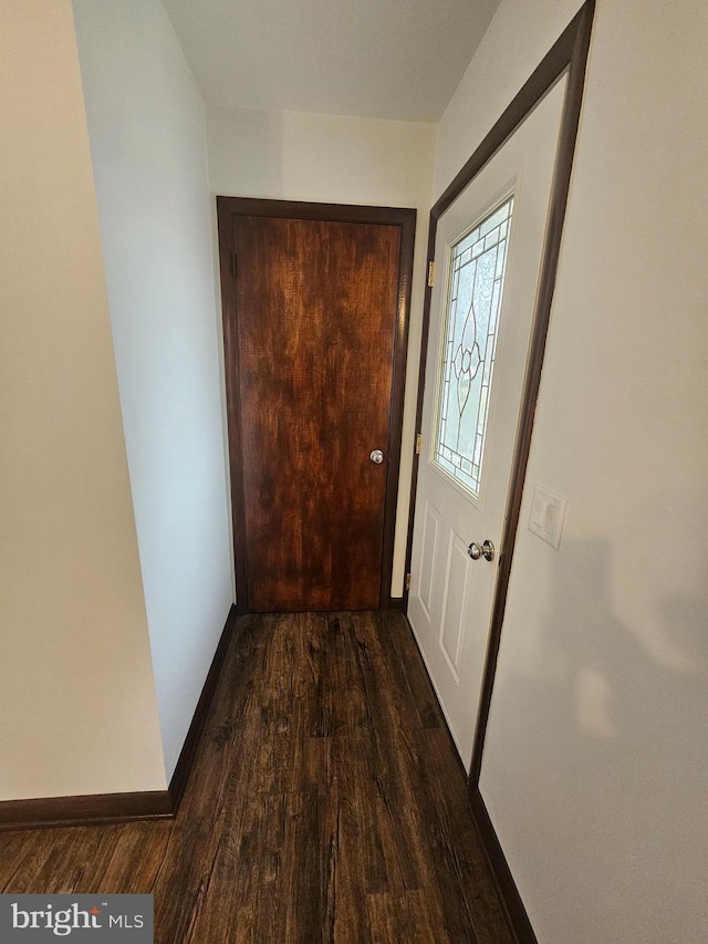 doorway to outside with wood finished floors and baseboards