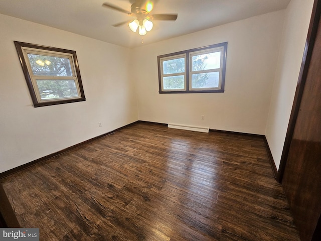 empty room featuring baseboard heating, wood finished floors, a ceiling fan, and baseboards