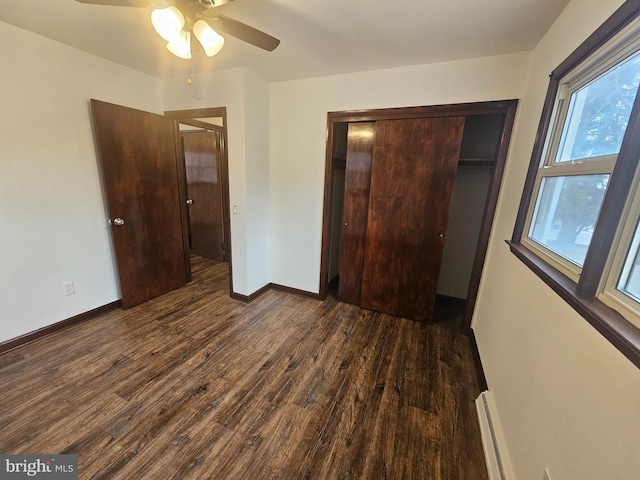 unfurnished bedroom with a closet, dark wood-style flooring, baseboards, and a ceiling fan