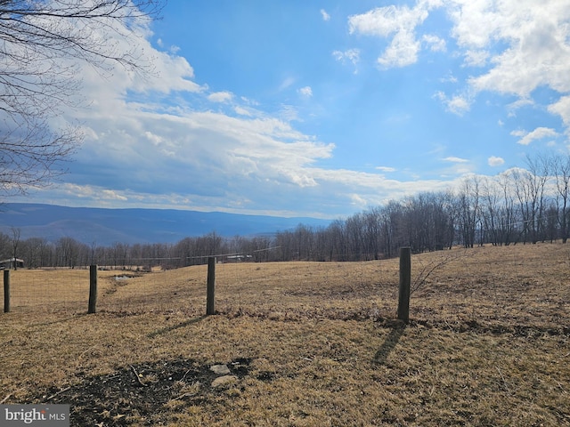 mountain view featuring a view of trees and a rural view