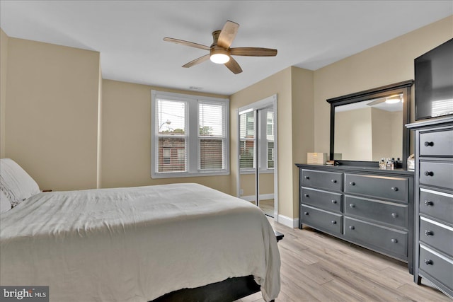 bedroom with a ceiling fan, light wood-style flooring, and baseboards