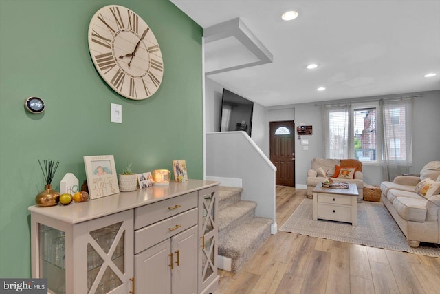 living area featuring recessed lighting, light wood finished floors, and stairs