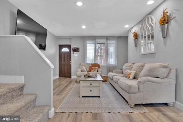 living room featuring baseboards, stairway, recessed lighting, and light wood-style floors