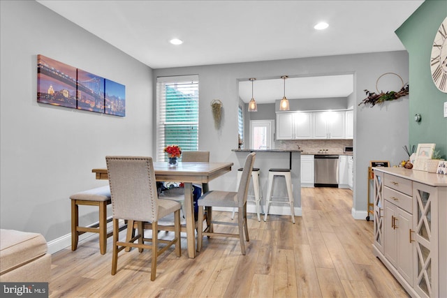 dining area featuring light wood finished floors, recessed lighting, and baseboards