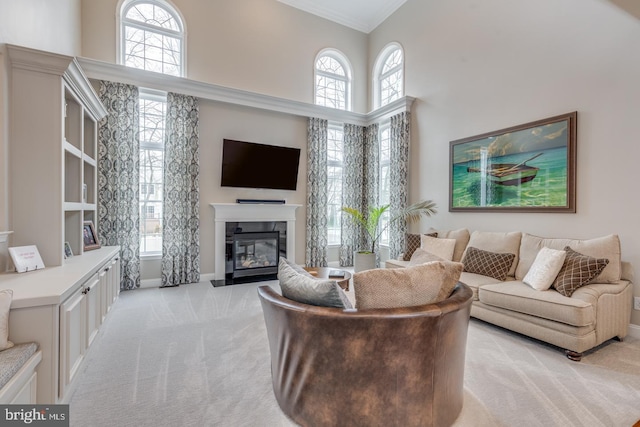 living room with a fireplace with flush hearth, baseboards, light colored carpet, and a high ceiling