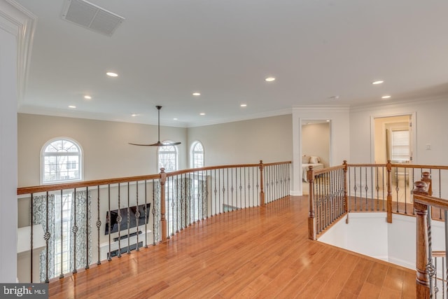 corridor with recessed lighting, visible vents, crown molding, and wood finished floors