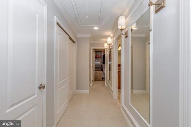 hallway with attic access, light carpet, and crown molding