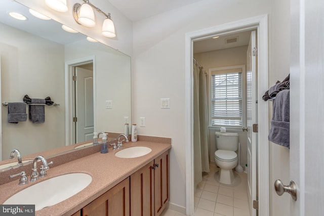 bathroom featuring double vanity, a sink, and tile patterned floors