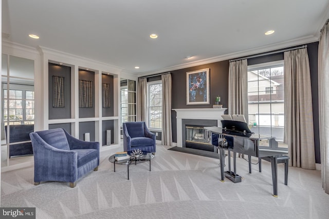 sitting room with a glass covered fireplace, a healthy amount of sunlight, and carpet