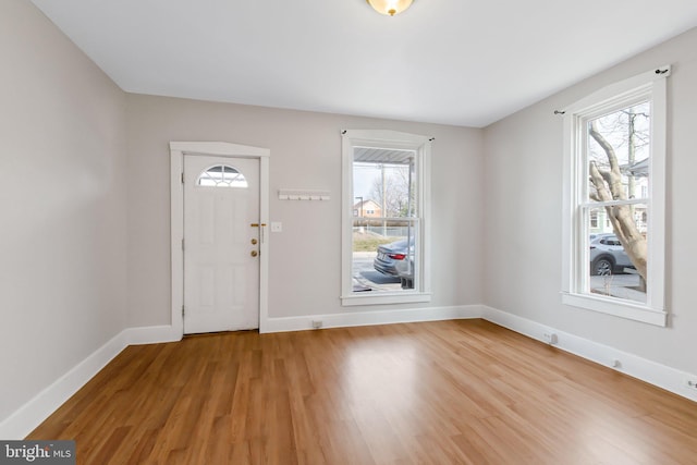 entrance foyer featuring baseboards, plenty of natural light, and light wood-style floors