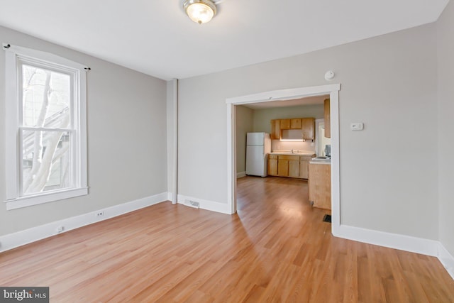 interior space with visible vents, baseboards, and light wood-style floors