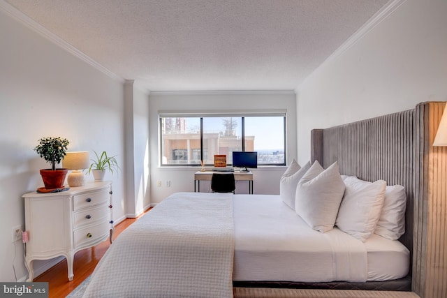 bedroom with baseboards, a textured ceiling, ornamental molding, and wood finished floors