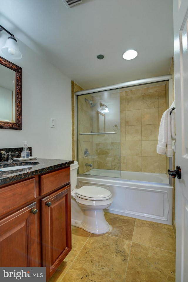 full bath with toilet, shower / bath combination with glass door, visible vents, and vanity